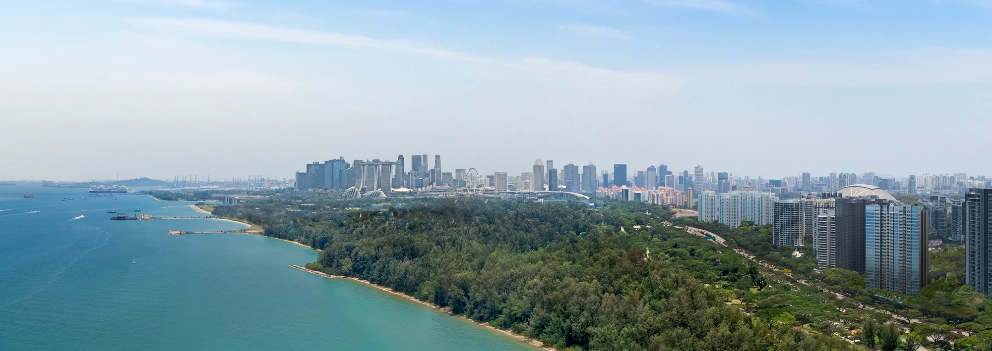 Meyer Blue, artist’s impression: an aerial view along the East Coast shoreline and the green belt of the park towards the Marina Bay skyline